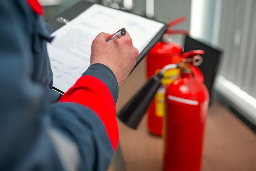 Beauftragter für Brandschutz füllt Dokument auf Klemmbrett aus